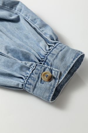 Близък изглед на ръкав на светлосиня дънкова риза с маншет и копче